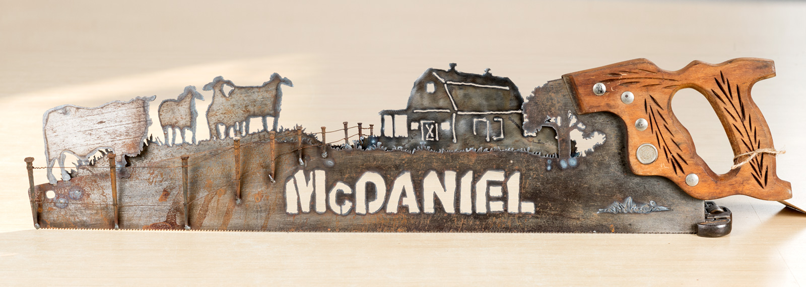 Vintage Brahman bulls hand cut metal hand saw wall art with natural patina rustic ranch decor